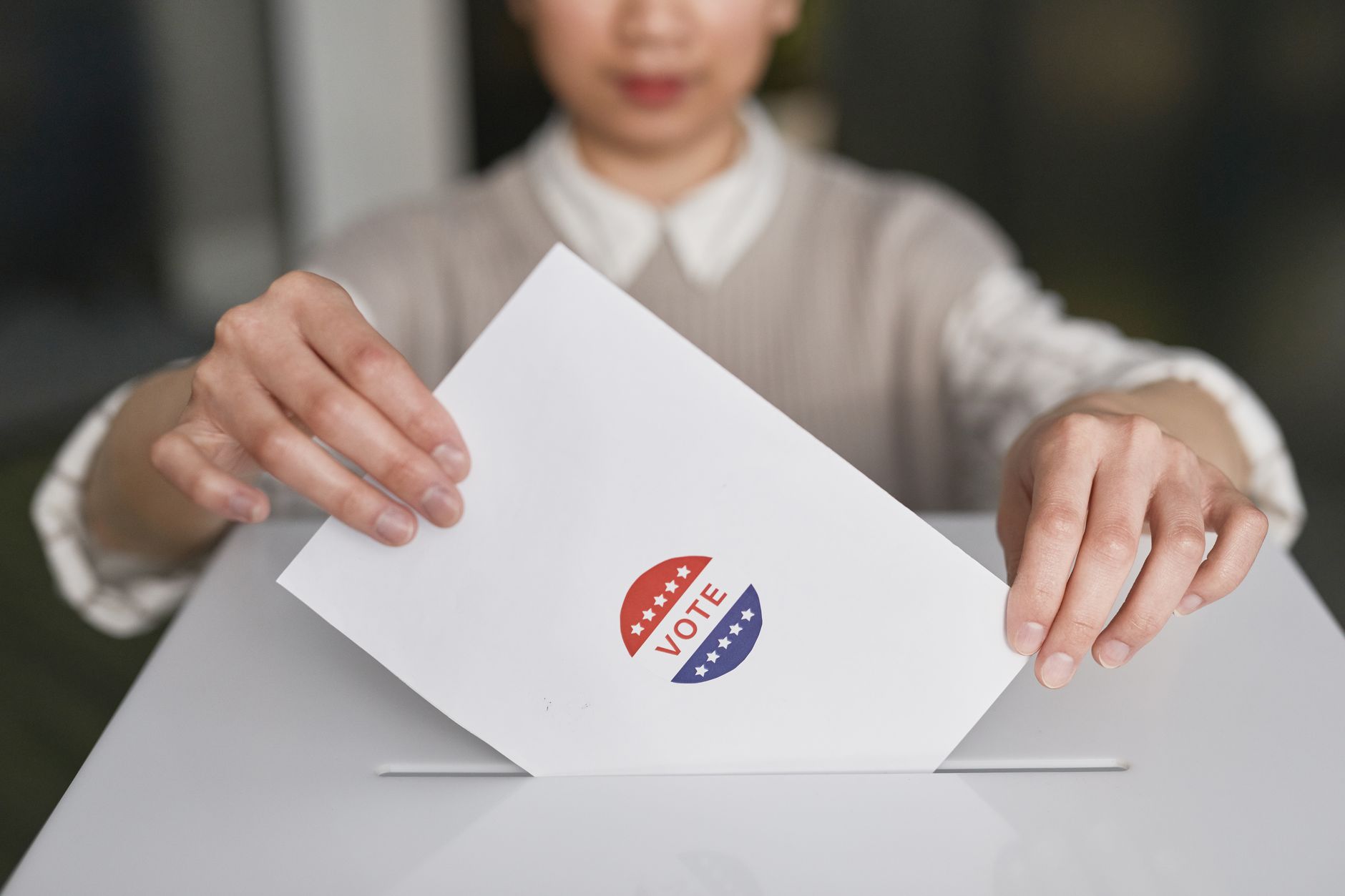 Persona introduce una boleta electoral en una urna