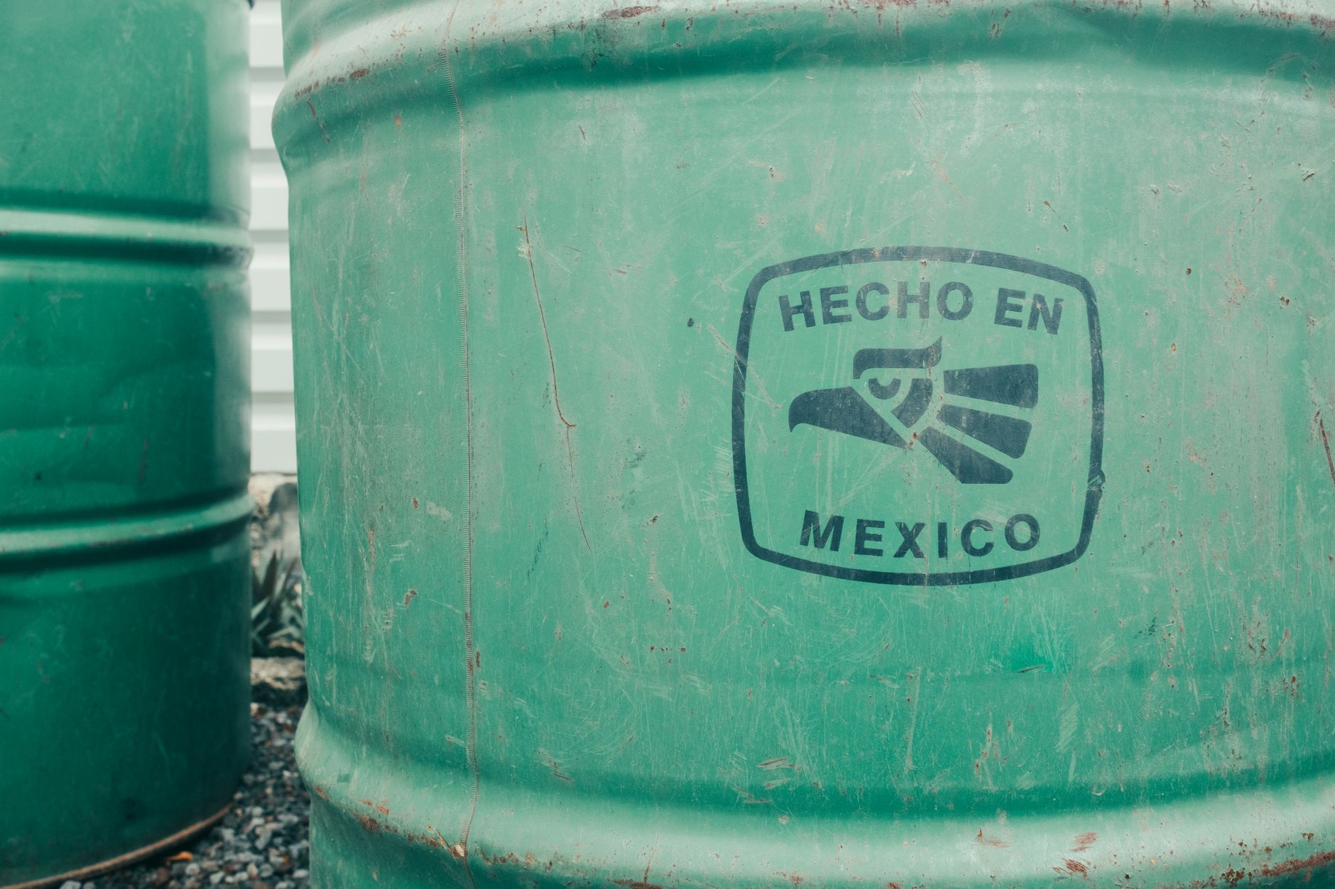 Recipiente industrial verde identificado con el sello Hecho en México.