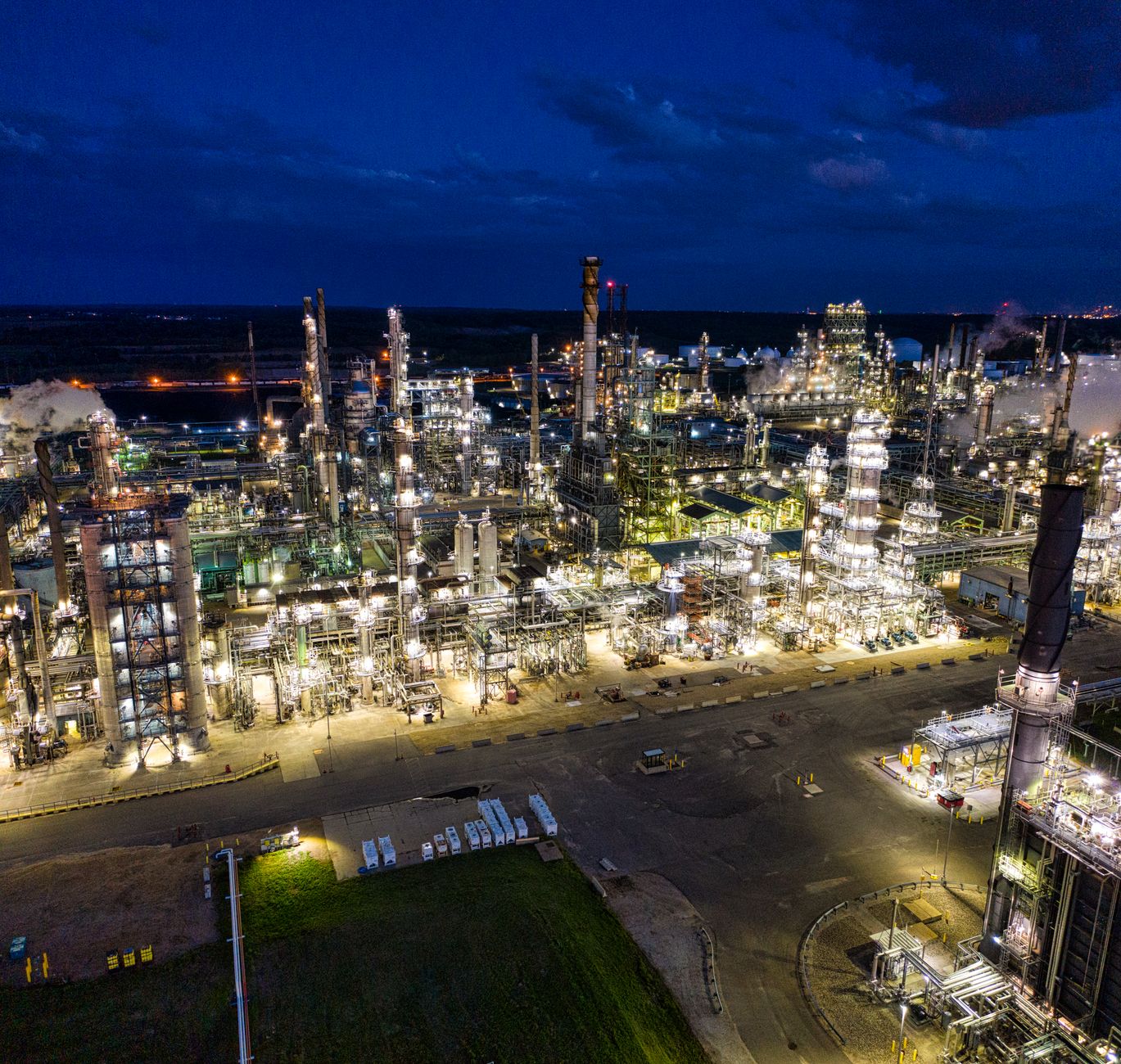 Complejo de refinación de petróleo iluminado durante la noche